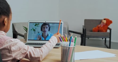 Child Interacts With Tutor on Laptop Screen
