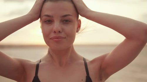 Glamorous Woman Relaxes on Beach During Sunrise