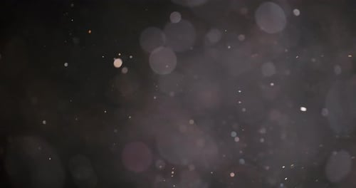 Blurred Light Particles Floating Over a Black Background