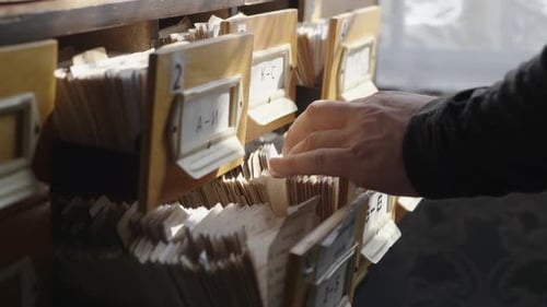 Man Opens Database Drawer. Young Librarian Opens Library Card Index. Archive, Database, Library