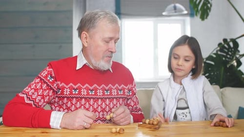 Grandfather and Granddaughter Playing Together Indoors