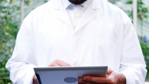 Scientist Using Tablet Device in Greenhouse