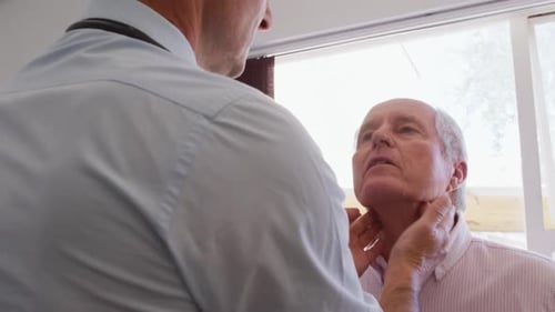 Doctor Examines Senior Man's Neck During Medical Checkup