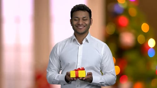 Man Presents Christmas Gift with Joyful Smile