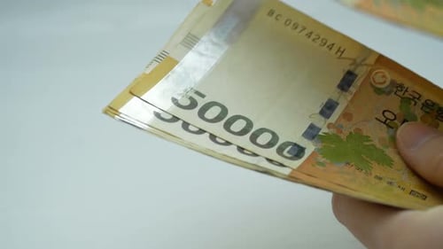 Counting Korean Won Banknotes in Hand