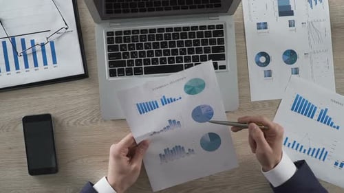 Mann im klassischen Anzug Analysiert Unternehmensstatistiken und gibt Daten auf dem Laptop ein