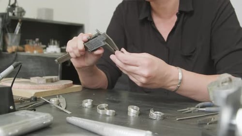 Measuring a Silver Ring with Caliper at Workbench