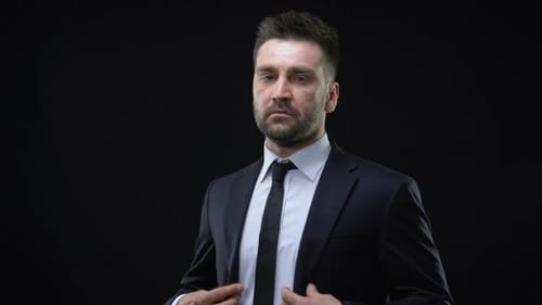 Selbstbewusster Firmenchef im formellen Anzug blickt in die Kamera, erfolgreicher Politiker