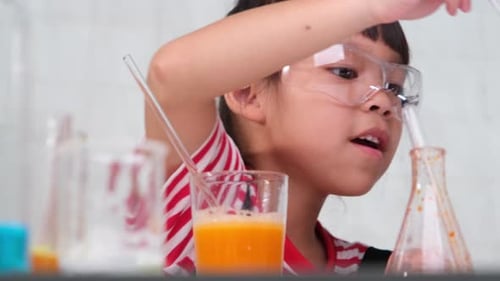 Child Doing Science Experiment with Pipette