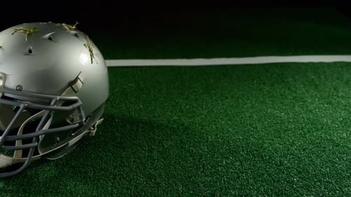 Silver Football Helmet on Turf Close Up
