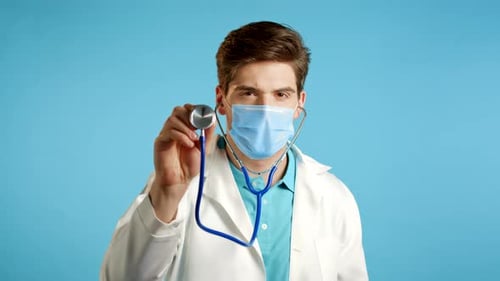 Young Doctor Examines with Stethoscope and Protective Mask