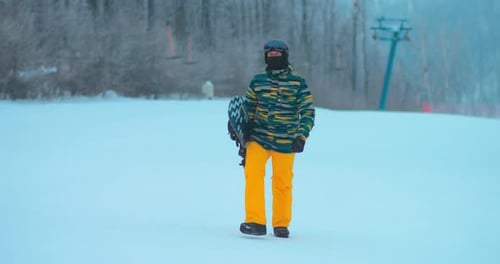 Snowboarder Walks Across Snowy Winter Mountain