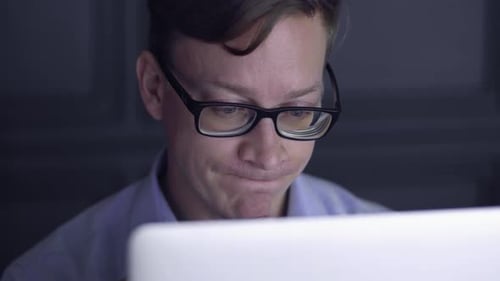 Focused Man Works Late at Night on Computer