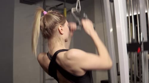 Woman Exercising Arms at a Gym on Pull Down