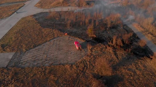 Fire Truck Extinguishing Grass Fire in Rural Field
