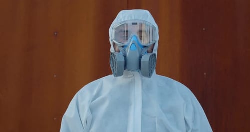 Retrato de trabalhador médico em traje de proteção geral e máscara olhando para a câmera, conceito de Covid