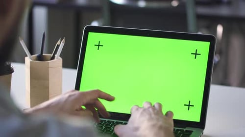 Closeup Man Worker Working on Laptop with Green Screen at Office