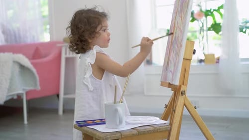 Little Child Painting on Easel in Home Studio