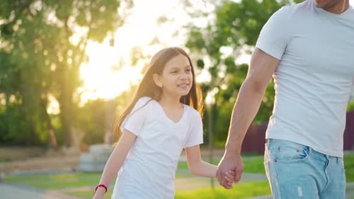 Dad and Daughter Walk Around Their Area at Sunset