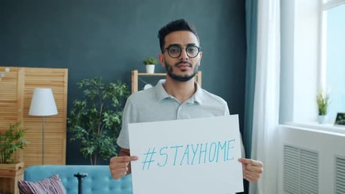 Young Adult Holding #StayHome Sign Indoors