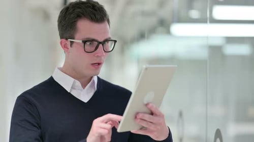 Man Reacts with Surprise to Tablet in Office