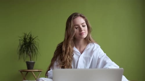 Young Adult Working on Laptop in Bedroom