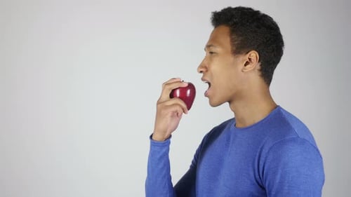 Young Adult Man Biting A Red Apple