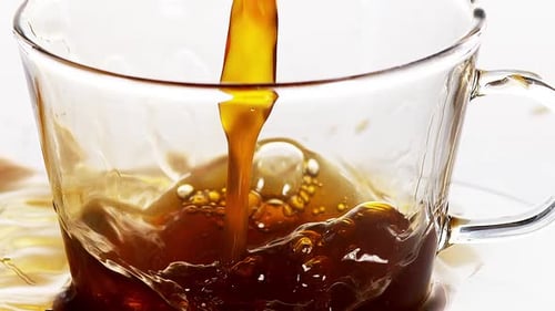 Dark Liquid Pouring into Glass Mug, Close Up