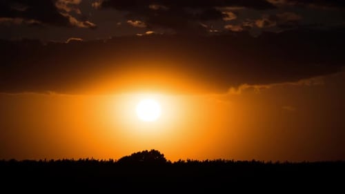 Dramatisch Sonnenuntergang durch die Wolken über dem Horizont, Timelapse