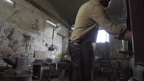 Blacksmith Making Decorative Element in Workshop