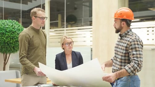 Team of Architects Working with Blueprints in Loft Office Discuss Building Design