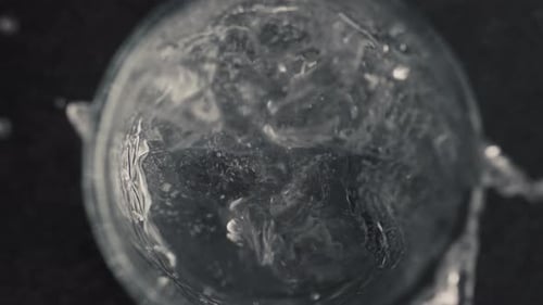 Ice Cube Dropped into Bubbling Glass of Water