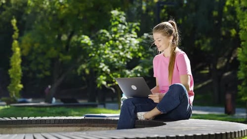 Happy Woman Having Video Conference Via Laptop in Park