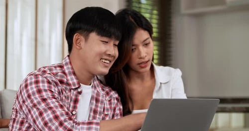 Happy Couple Using Laptop at Home Together