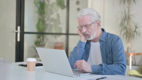 Senior Old Man Taking Nap While Using Laptop in Office