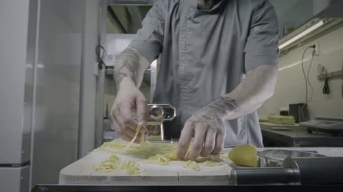 Chef Making Pasta with Pasta Machine in Kitchen