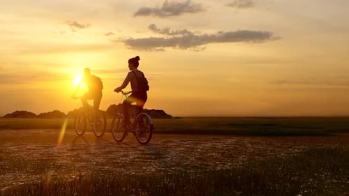 Paar wandert mit Fahrrädern bei Sonnenuntergang