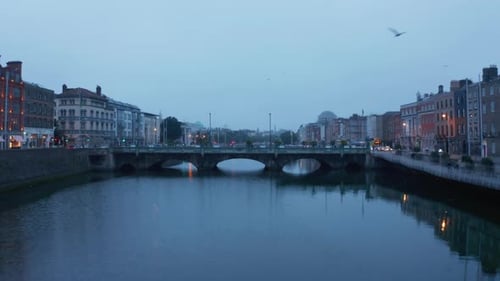 Vuelo bajo sobre el tranquilo río Liffey al anochecer