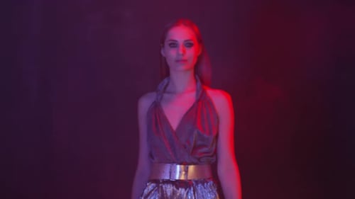 Woman Posing Glamorously in Red Lit Environment