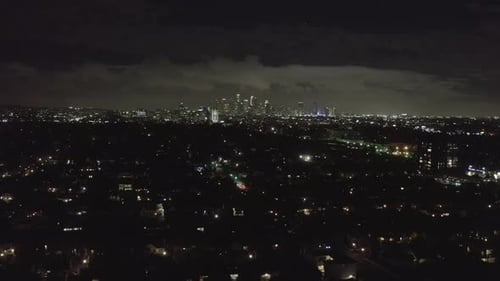 AERIAL: Over Dark Hollywood Los Angeles at Night with Clouds Over Downtown and City Lights