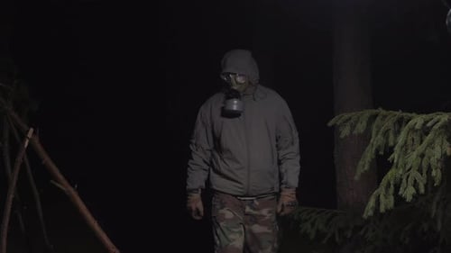 Man in a Gas Mask Escapes From Coronavirus in the Woods at Night