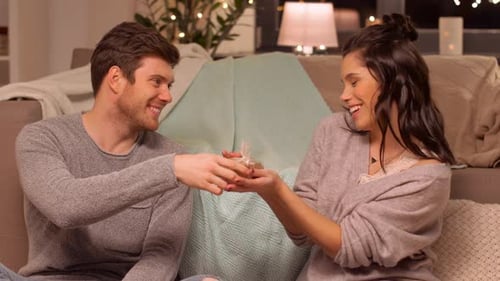 Man Giving Gift to Smiling Woman at Home