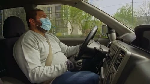 Man Drives Car Wearing Mask and Gloves