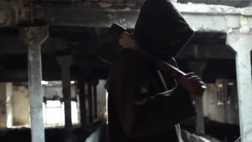 Hooded Figure with Axe in Derelict Building