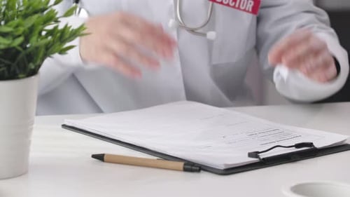 Doctor Reviews Patient Information on Clipboard in Office