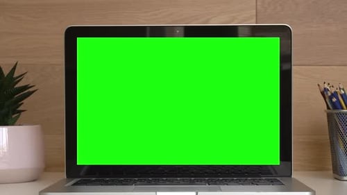 Laptop Displaying Green Screen on White Desk