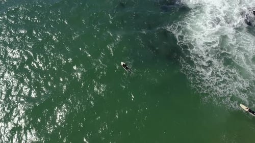Surfer riding and turning with spray on blue ocean wave, surfing ocean. Aerial