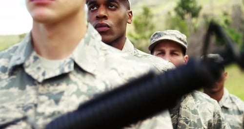 Four Young Adults in Camouflage Uniforms with Rifles