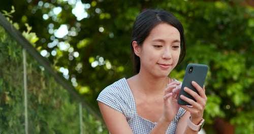 Woman Using Smartphone Device in Urban Park Setting