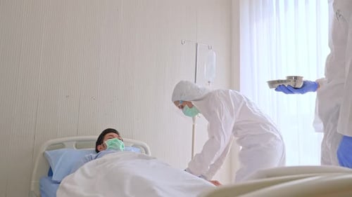 Medical Workers Treat Patient in Hospital Room